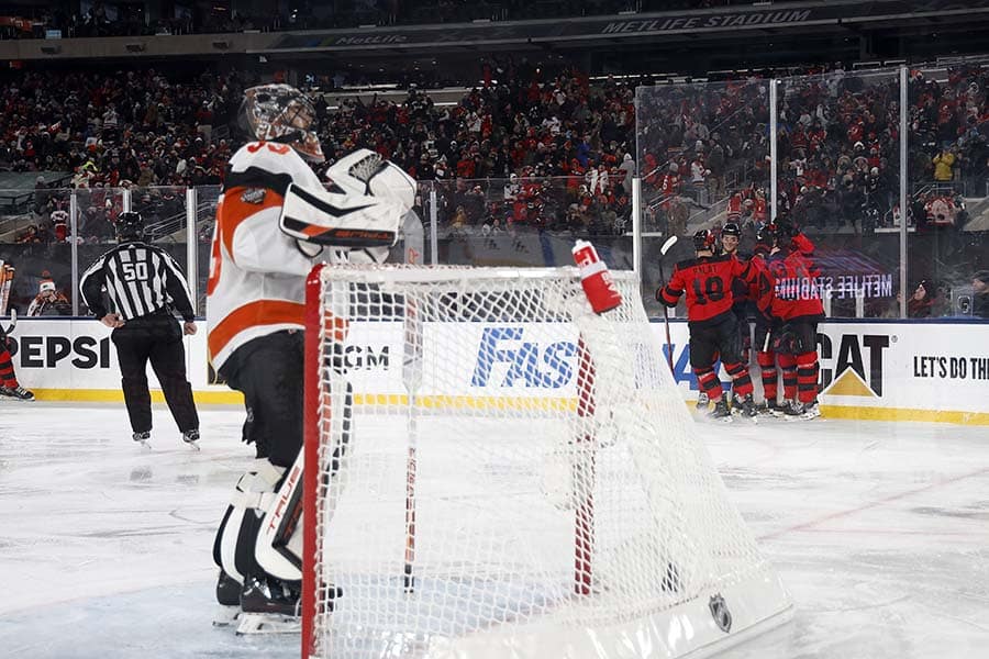 Samuel Ersson #33 of the Philadelphia Flyers reacts after allowing a goal to Nico Hischier #13 of the New Jersey Devils during the third period during the 2024 Navy Federal Credit Union Stadium Series at MetLife Stadium on February 17, 2024 in East Rutherford, New Jersey.