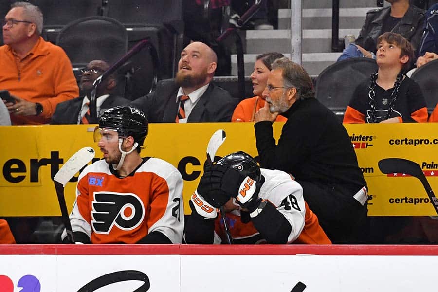 Philadelphia Flyers left wing Noah Cates (27) and center Morgan Frost (48) on the bench with head coach John Tortorella in the final seconds of loss against the Washington Capitals during the third period at Wells Fargo Center.