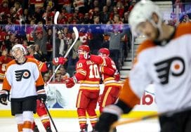 CALGARY, CANADA - OCTOBER 12: Jonathan Huberdeau #10 of the Calgary Flames celebrates his third period goal on the Philadelphia Flyers with teammates at the Scotiabank Saddledome on October 12, 2024, in Calgary, Alberta, Canada.