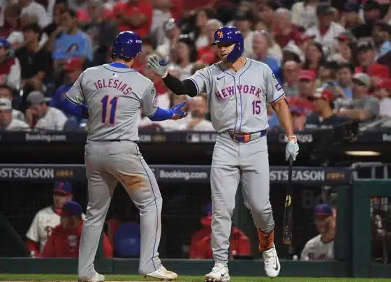 Oct 5, 2024; Philadelphia, PA, USA; New York Mets second baseman Jose Iglesias (11) celebrates with New York Mets outfielder Tyrone Taylor (15) after scoring a run against the Philadelphia Phillies in the eighth inning in game one of the NLDS for the 2024 MLB Playoffs at Citizens Bank Park.